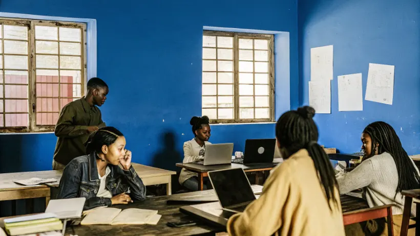 Young people attending skills training workshop in community center with instructor demonstrating technical skills for employment opportunities